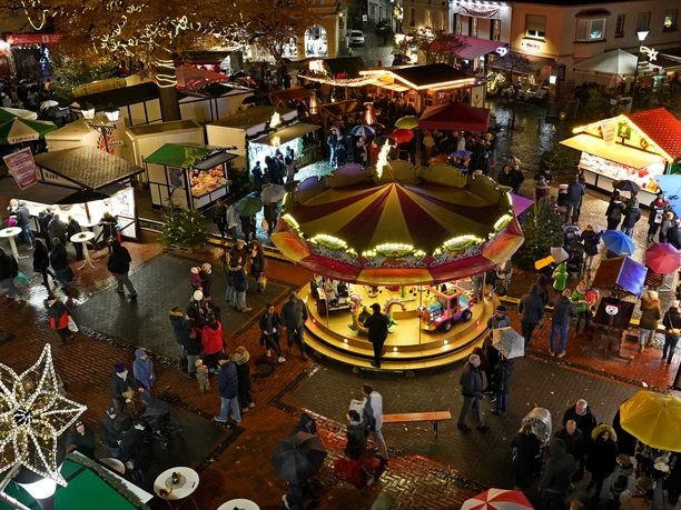 Blick auf den Weihnachtsmarkt in Hilden Luftaufnahme eines beleuchteten Weihnachtsmarktes in Hilden mit einer Drehkarussell, Ständen und Besuchern.