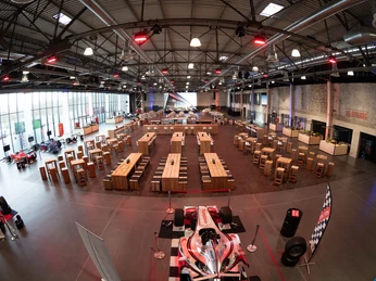Eventraum Flugzeug-Hangar Eventhalle Flugzeug-Hangar mit Mischbestuhlung und einem ausgestellten RennautoEvent hall, airplane hangar with mixed seating and a race car on display