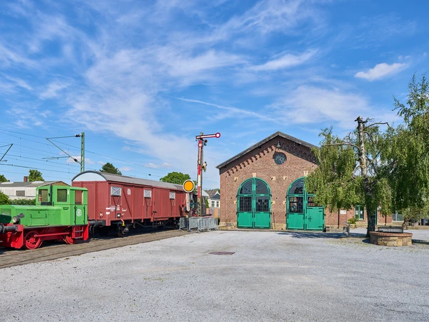 Bahnsteig mit Bahn am Lokschuppen (Erkrath-Hochdahl) Bahnsteig mit nostalgischer Lok am historischen Lokschuppen in Erkrath-Hochdahl bei klarem Himmel.