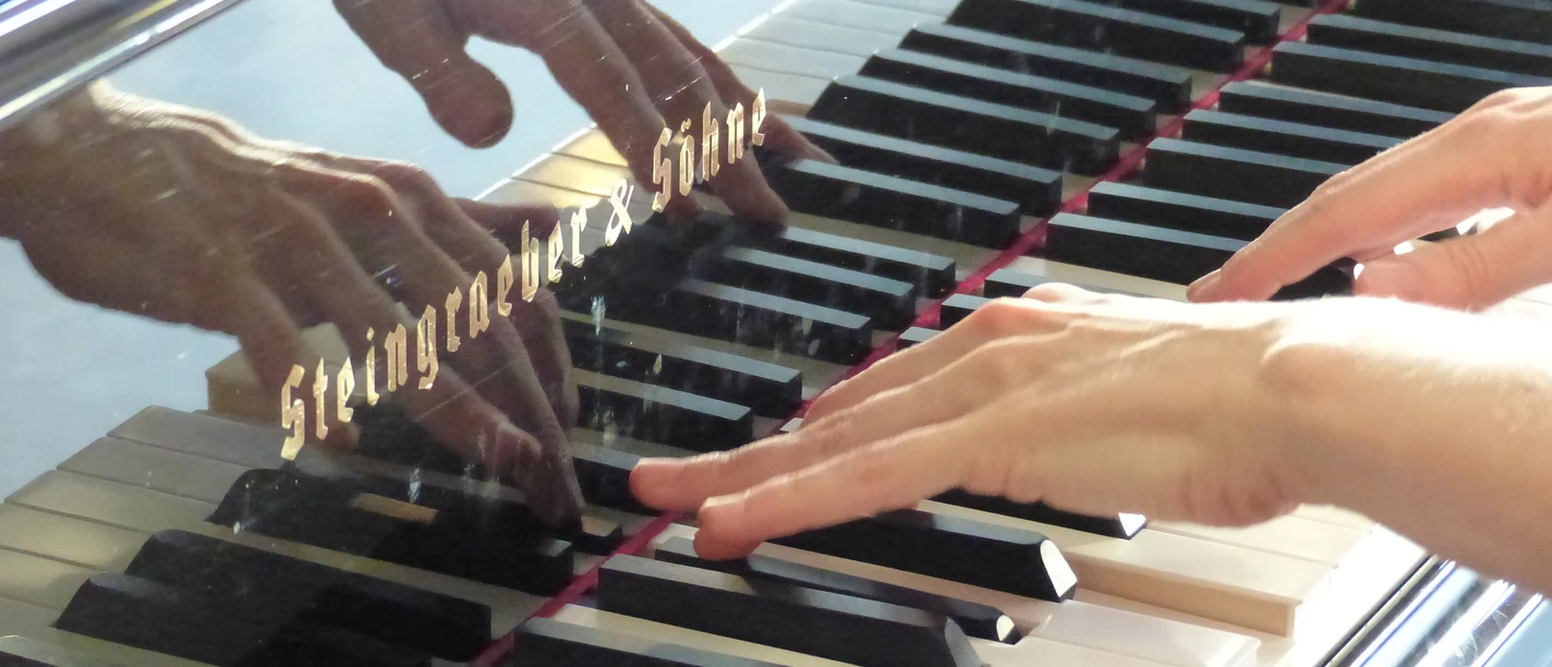 Hände auf einer Klaviertastatur, die spielen