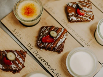 BrauhausAbends-74 (1).jpg Dessertteller mit Schokoladenkuchen, Erdbeerscheiben und Crème Brûlée aus der Nahaufnahme.