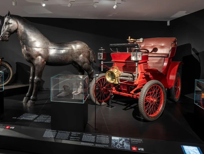 Kölnisches Stadtmuseum Darstellung eines historischen Automobils neben einer metallischen Pferdeskulptur im Kölner Stadtmuseum.Depiction of a historic automobile next to a metal horse sculpture in the Cologne City Museum.