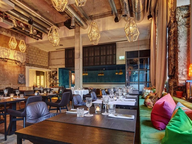 Modern Restaurant Anker interior with set tables, pendant lights and colourful window seating