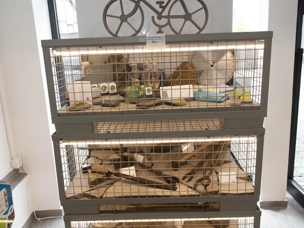 Bergisches Grauwacke-Museum Museumsvitrine mit historischen Fahrradzubehörteilen und Modell eines Fahrrads oberhalb.