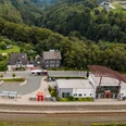 Drohnenaufnahme des Winterberger Bahnhofs mit Parkplatz und Bahngleisen.