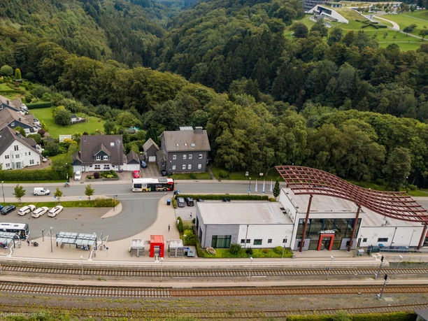 Drohnenaufnahme des Winterberger Bahnhofs mit Parkplatz und Bahngleisen.