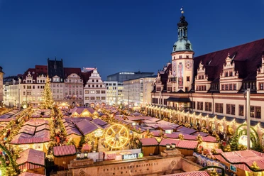 View of the brightly lit Christmas market on the market square in Leipzig in the evening