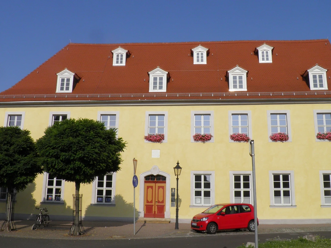 Infopoint und Bibliothek im Napoleonhaus Pegau Das Bild zeigt die gelbe Front des Napoleonhauses, welche unter anderem die Tourist-Information beherbegt.The picture shows the yellow front of the Napoleonhaus, which also houses the tourist information centre.