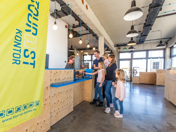 Innenraum des Tourist-Kontor Zwenkau Das Bild zeigt den Innenraum des Tourist-Kontors Zwenkau, eine junge Familie lässt sich gerade am Tresen beraten.