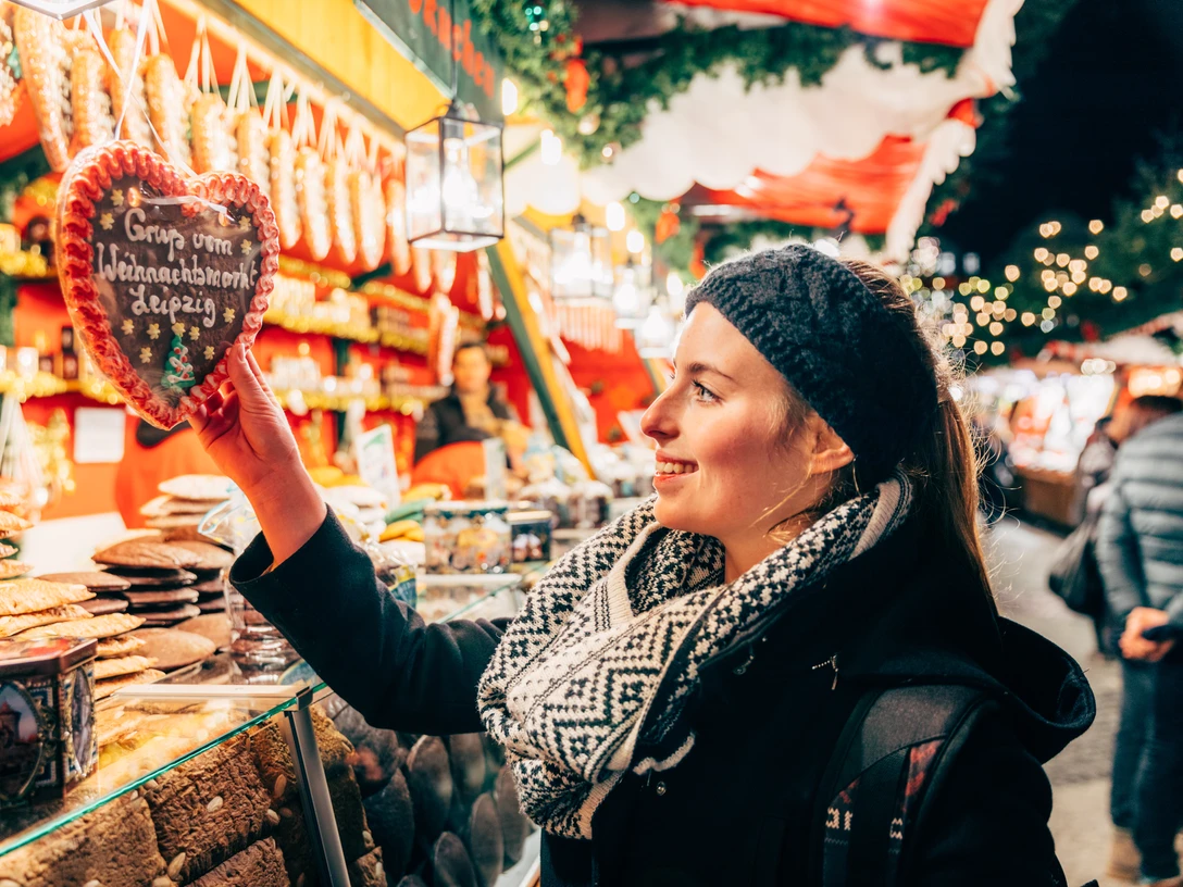 Weihnachtsmarkt auf dem Naschmarkt - Weihnachten in Leipzig Eine Frau steht vor einem Lebkuchenstand auf dem Leipziger Weihnachtsmarkt und greift nach einem Lebkuchenherz