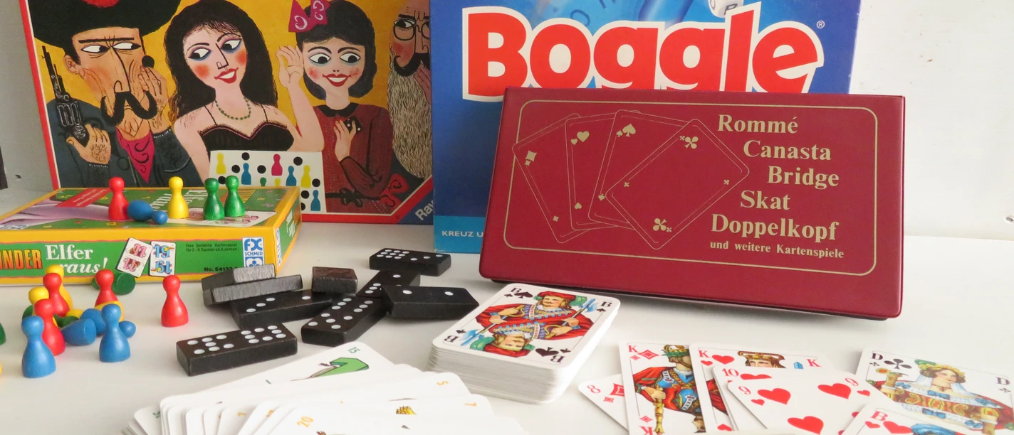 Spieleabend Verschiedene Gesellschaftsspiele, darunter Malefiz, Boggle und Karten, liegen nah beieinander.