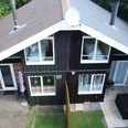 Ferienpark Extertal_Haus Kristin Holzferienhaus mit doppeltem Giebeldach, Veranda und Terrasse im grünen Waldgebiet, ruhig gelegen.