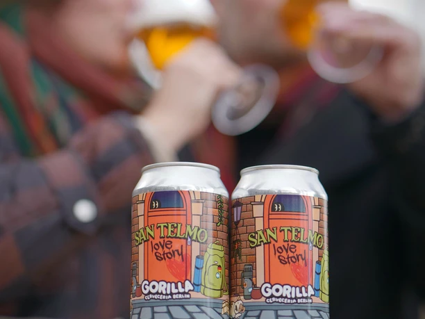 AllezHop7.JPG Zwei bunt gestaltete Bierdosen mit der Aufschrift "San Telmo" stehen nebeneinander. Im Hintergrund trinken zwei Personen an ihren Biergrläsern.