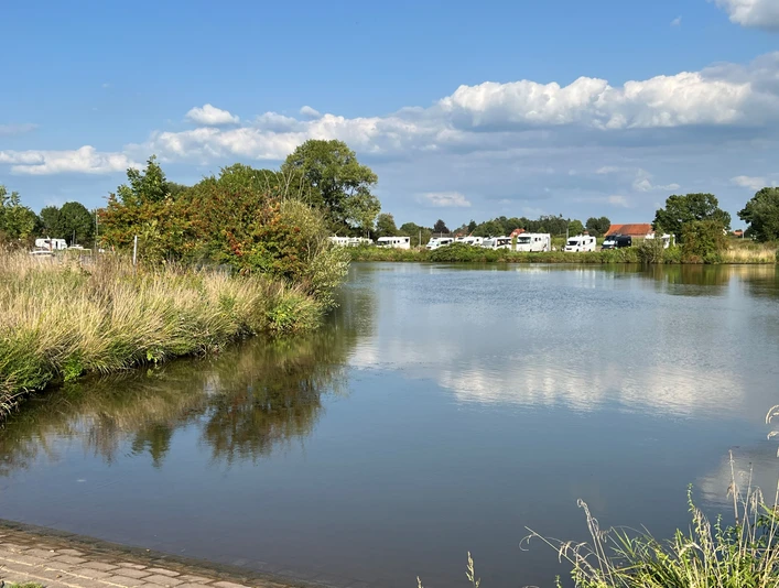 Womo Landesbergen Freizeit und Erholung: Wohnmobilstellplatz am See mit üppiger Vegetation, ruhig und naturverbunden.