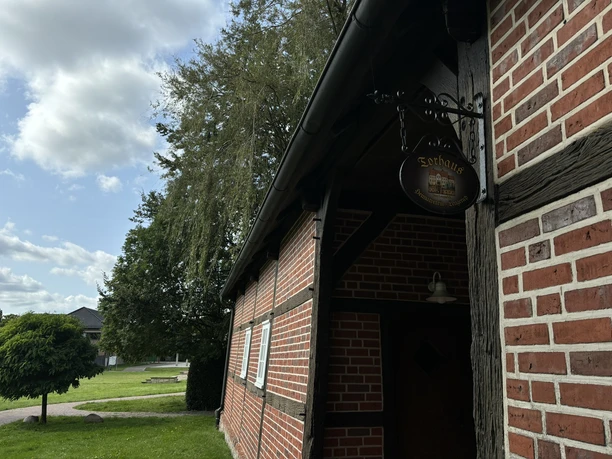 Torhaus am Bürgerpark ©Emsland Tourismus GmbH Backsteinbau mit Fachwerkelementen im Bürgerpark Lengerich, flankiert von Bäumen und Grünflächen.