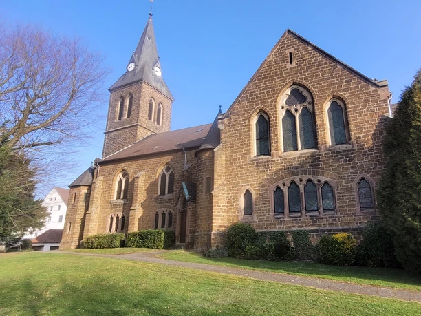 Kirche Schnathorst Die Backsteinkirche Schnathorst mit spitzem Turm steht in einer grünen Umgebung unter klarem Himmel.