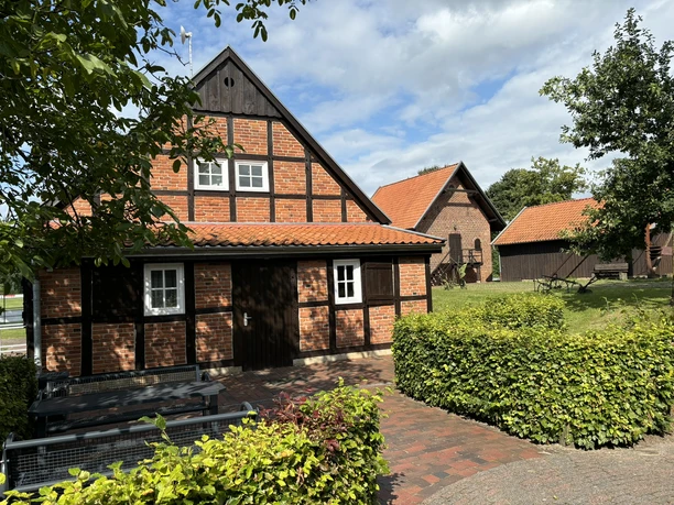 Heimathof Bramsche ©Emsland Tourismus GmbH Historisches Fachwerkhaus mit roten Ziegeldächern und Hofanlage unter blauem Himmel im Grünen.