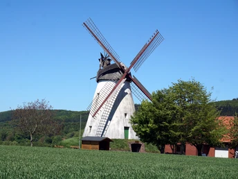 Windmühle Struckhof Windmühle Struckhof in ländlicher Umgebung mit bewaldeten Hügeln und klarem blauen Himmel im Hintergrund.
