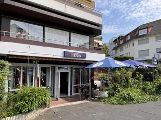 Eingang zum Restaurant Namaste India mit Außenterrasse und Sonnenschirmen