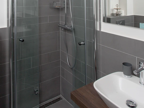 Badezimmer im Hotel Angerland, Ratingen Modernes Badezimmer im Hotel Angerland, Ratingen mit bodenebener Dusche und Waschbecken.