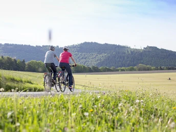 Paar beim Genussradeln durch Felder Paar beim Genussradeln durch Felder