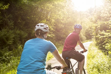 Biker-Paar beim Genussradeln im Sonnenschein Biker-Paar beim Genussradeln im Sonnenschein