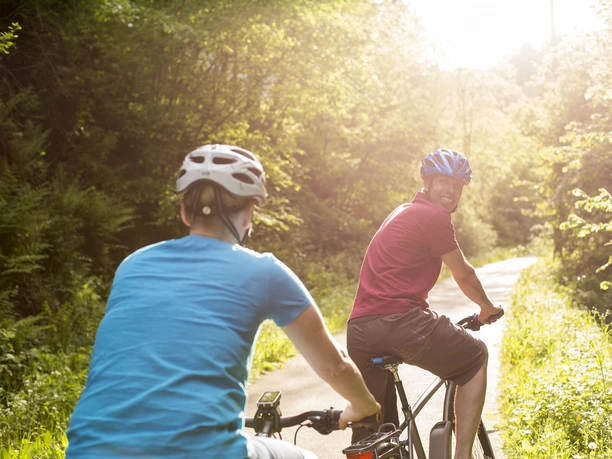 Biker-Paar beim Genussradeln im Sonnenschein Biker-Paar beim Genussradeln im Sonnenschein