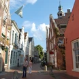 2106_altstadt_von_leer-original Gepflasterte Gasse in der Altstadt von Leer mit historischen Backsteinhäusern und Passanten bei Sonne.Cobbled alley in the old town of Leer with historic brick houses and passers-by in the sun.Brostensbelagt gyde i den gamle bydel i Leer med historiske murstenshuse og forbipasserende i solen.Keienstraat in het oude centrum van Leer met historische bakstenen huizen en voorbijgangers in de zon.