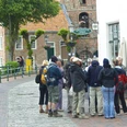 Dorfführung Greetsiel Eine Gruppen Menschen bei einer Dorfführung durch Greetsiel, vor dem Restaurant Greetsieler Börse, im Hintergrund die Kirche.