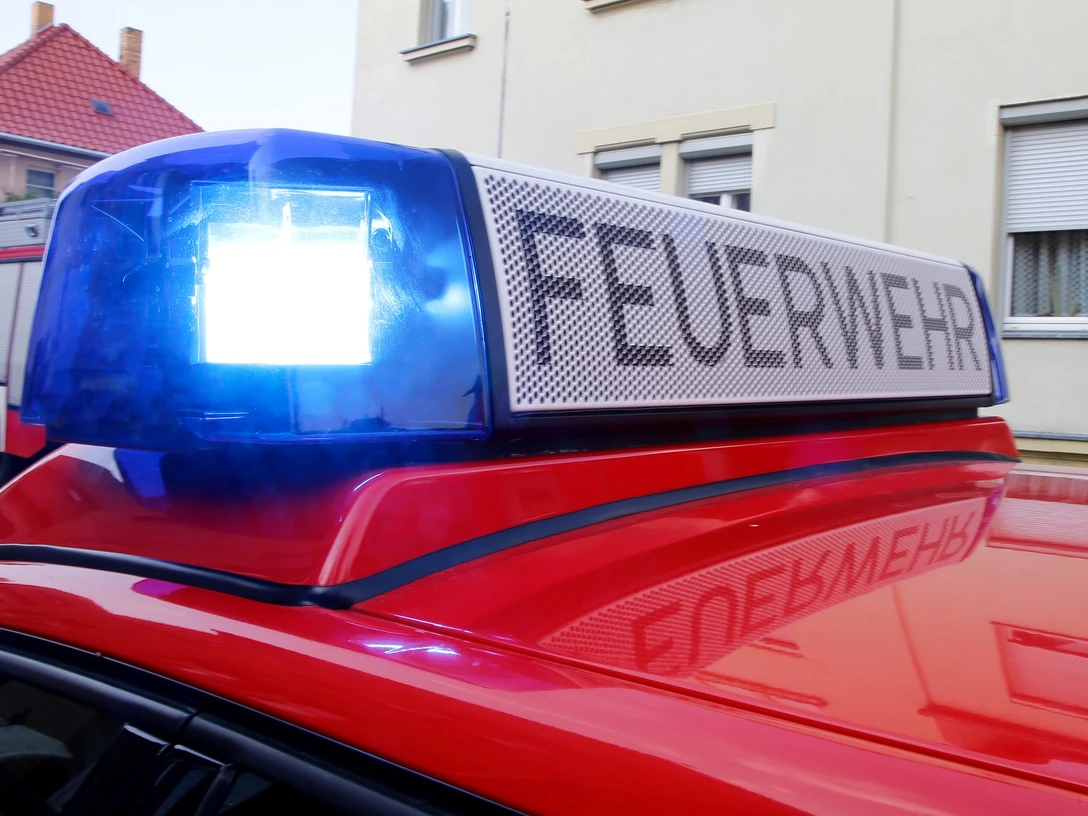 Feuerwehrfest Nahaufnahme eines roten Feuerwehrwagens mit blauem Blaulicht und leuchtender Aufschrift Feuerwehr