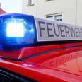 Feuerwehrfest Nahaufnahme eines roten Feuerwehrwagens mit blauem Blaulicht und leuchtender Aufschrift Feuerwehr