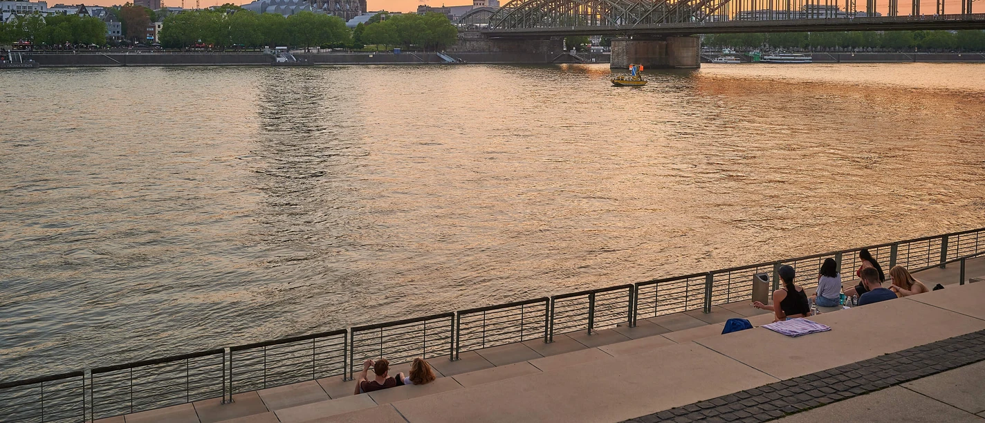 Promenade mit Freitreppe in Köln-Deutz Panoramablick auf den Rheinboulevard mit dem Kölner Dom und der eindrucksvollen Hohenzollernbrücke im Sonnenuntergang.