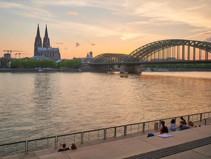 Rhine Boulevard Panoramablick auf den Rheinboulevard mit dem Kölner Dom und der eindrucksvollen Hohenzollernbrücke im Sonnenuntergang.Panoramic view of the Rhine boulevard with Cologne Cathedral and the impressive Hohenzollern Bridge at sunset.
