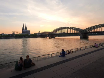 Rheinboulevard Atemberaubendes Panorama bei Sonnenuntergang: Blick auf den Rhein, die Kölner Domspitzen und die Hohenzollernbrücke.Breathtaking panorama at sunset: view of the Rhine, the spires of Cologne Cathedral and the Hohenzollern Bridge.