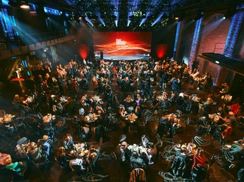 Film Festival Cologne A festively lit hall full of round tables and elegant guests at the Film Festival Cologne.