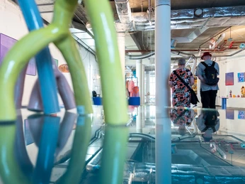 Passagen Blick in modernes Kunst- oder Designstudio mit farbenfrohen Plastikskulpturen und Besuchern.View of a modern art or design studio with colorful plastic sculptures and visitors.