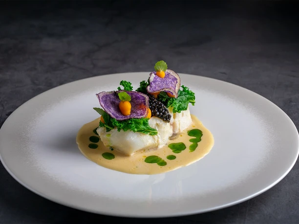 Excelsior Hotel Ernst_HanseStube restaurant 2.jpg Vegetables on fish fillet on a white plate