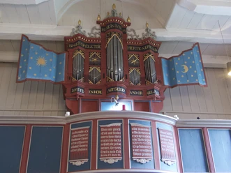 Kirche Westerhusen Historische Orgel der Kirche Westerhusen mit blauen, sternenverzierten Flügeln.