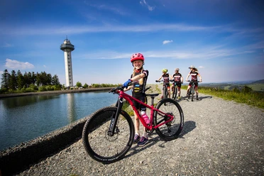 Familie mit Kindern bei einer Mountainbiketour am Bergsee auf dem Ettelsberg Familie mit Kindern bei einer Mountainbiketour am Bergsee auf dem Ettelsberg