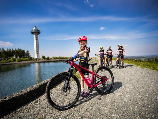 Familie mit Kindern bei einer Mountainbiketour am Bergsee auf dem Ettelsberg Familie mit Kindern bei einer Mountainbiketour am Bergsee auf dem Ettelsberg