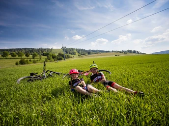 Kinder mit Bikes im Gras an der Talstation der Ettelsberg-Seilbahn Kinder mit Bikes im Gras an der Talstation der Ettelsberg-Seilbahn