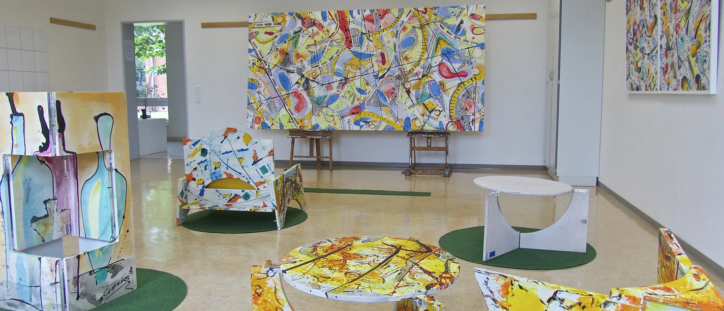 Greetsieler Woche Ausstellung Bunte Kunstobjekte und Gemälde in einem hellen Ausstellungsraum der Greetsieler Woche.