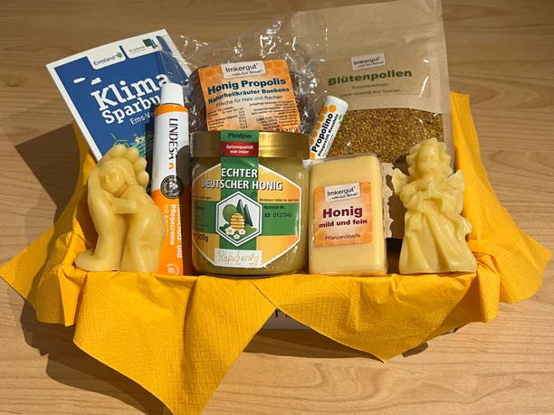 Imkerei Rensen ©Emsland Tourismus GmbH (2).png Geschenkset mit Honig, Blütenpollen, Bonbons, Seife und Bienenwachskerzen auf gelbem Tuch