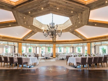 Der Pavillion in Lohmanns Romantik Hotel Gravenberg in Langenfeld Großer, heller Raum mit Holzakzenten, elegantem Kronleuchter, gedeckten Tischen und Panoramafenstern.