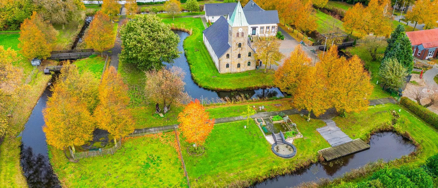 Burgpark-Venhaus©MedienAtelierEmsland.jpg Luftaufnahme des Burgparks Venhaus mit Wassergräben, altem Gutshaus und herbstlich gefärbten Bäumen