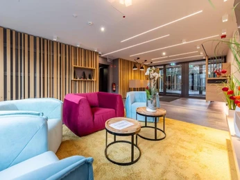 Lobby im Serways Hotel Hösel in Ratingen Moderne Lobby des Serways Hotel Hösel in Ratingen mit bunten Sitzmöbeln und hellem Teppich.