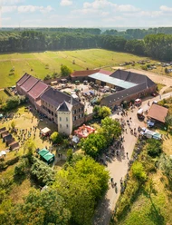 Luftaufnahme von Haus Bürgel, einem historischen Anwesen mit grünen Wiesen und befestigten Wegen.