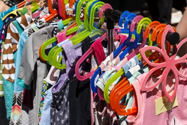 Kindersachen Kindersachen auf einem Flohmarkt hängen auf einem Ständer.