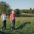Frauen beim Spaziergang auf einer Wiese Frauen beim Spaziergang auf einer Wiese