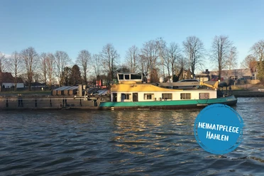 Minden - hahlen.png Das Bild zeigt den Mittellandkanal, auf dem ein Frachtschiff fährt.